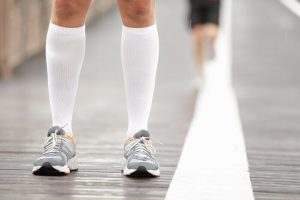 Pedorthist. Running Shoes Closeup And Compression Socks On Male Runner Closeup.