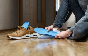Custom Orthotics. Man putting new custom orthotics in his shoes.