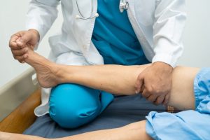Are Pedorthist Services Covered by Insurance in Ottawa? Asian doctor physiotherapist examining, massaging and treatment knee and leg of senior patient in orthopedist medical clinic nurse hospital.