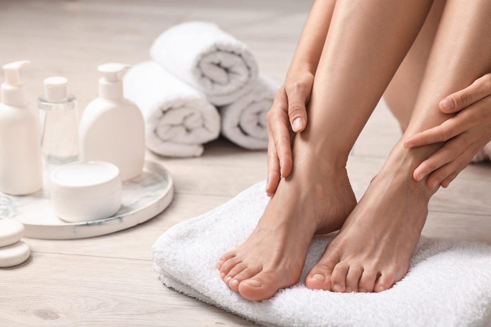 Why Choose Healthy Steps Pedorthic for Foot Care in Ottawa? Woman touching her smooth feet on floor, closeup.