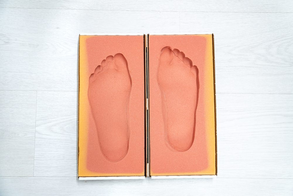 How Custom Orthotic Insoles Relieve Foot Pain & Improve Mobility in Ottawa? Top view of an insole mould with a patient's footprints.